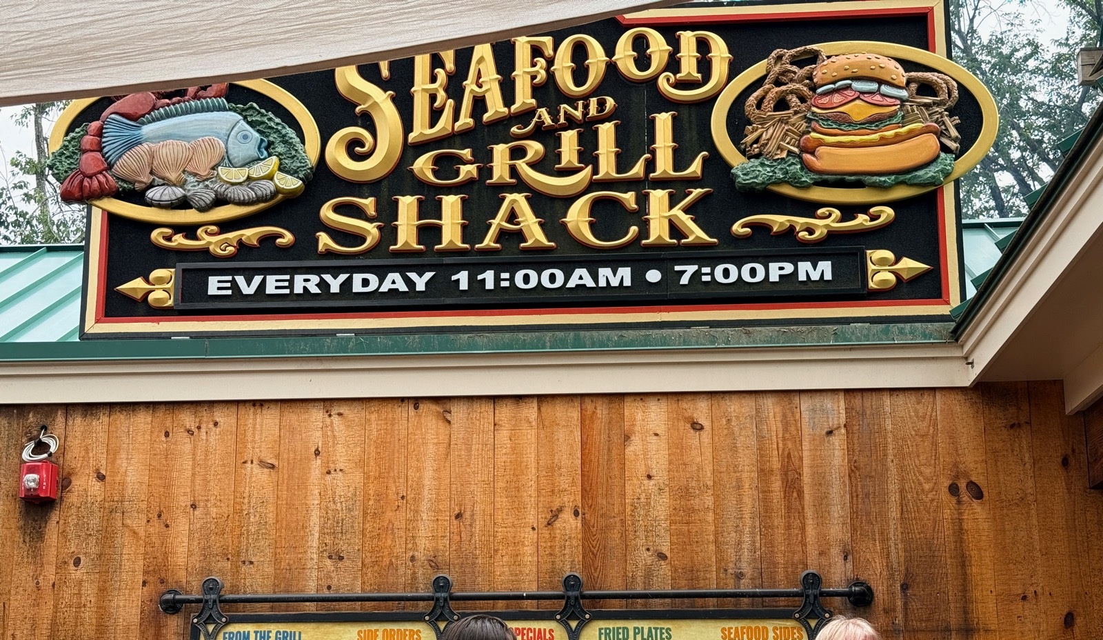 The carved Seafood and Grill Shack sign over the wooden order window at Kimball Farm