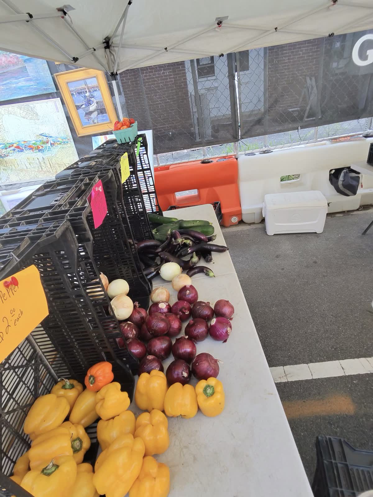A painter's booth with framed prints of brick streets at a farmers market